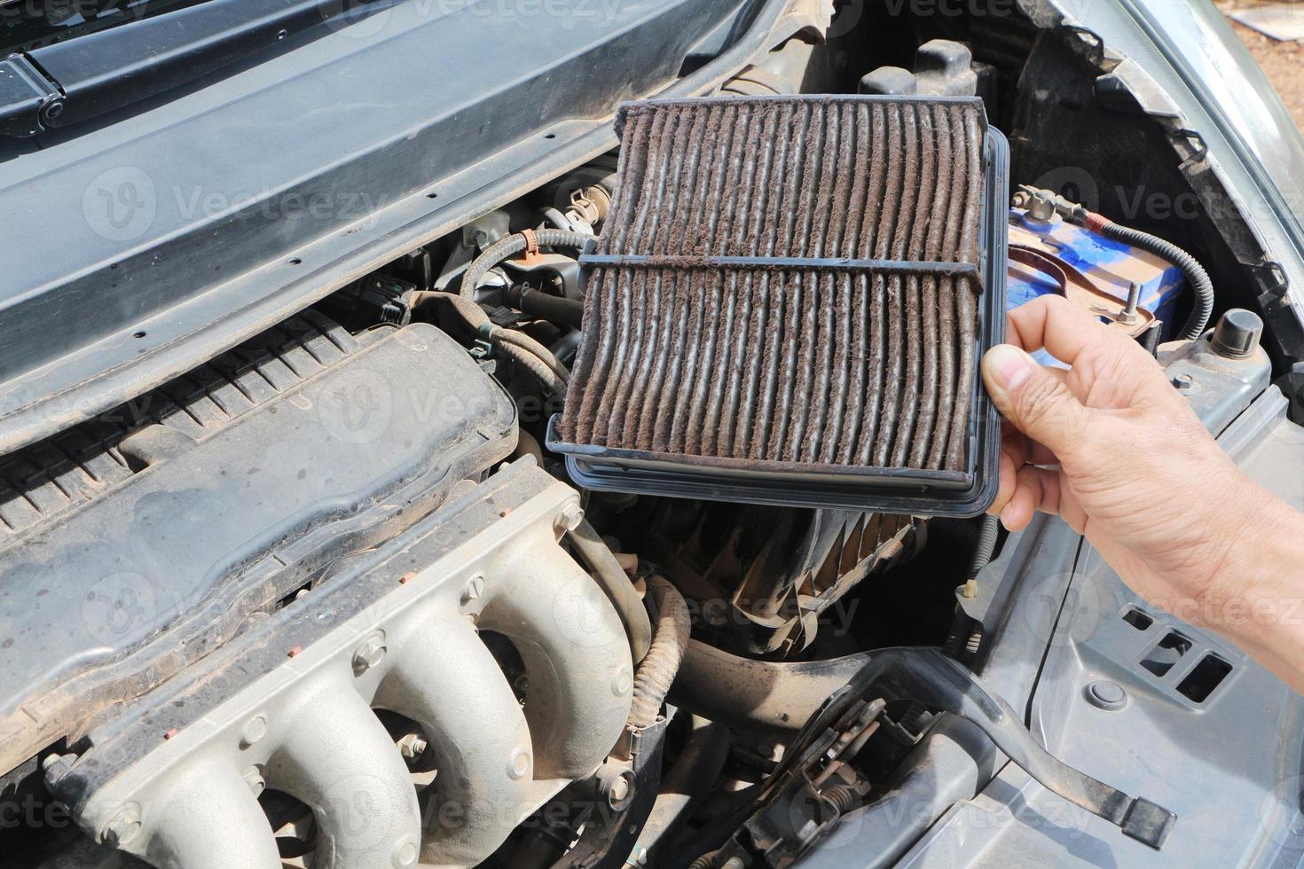 Man with a dirty car air conditioner filter in his hand. photo