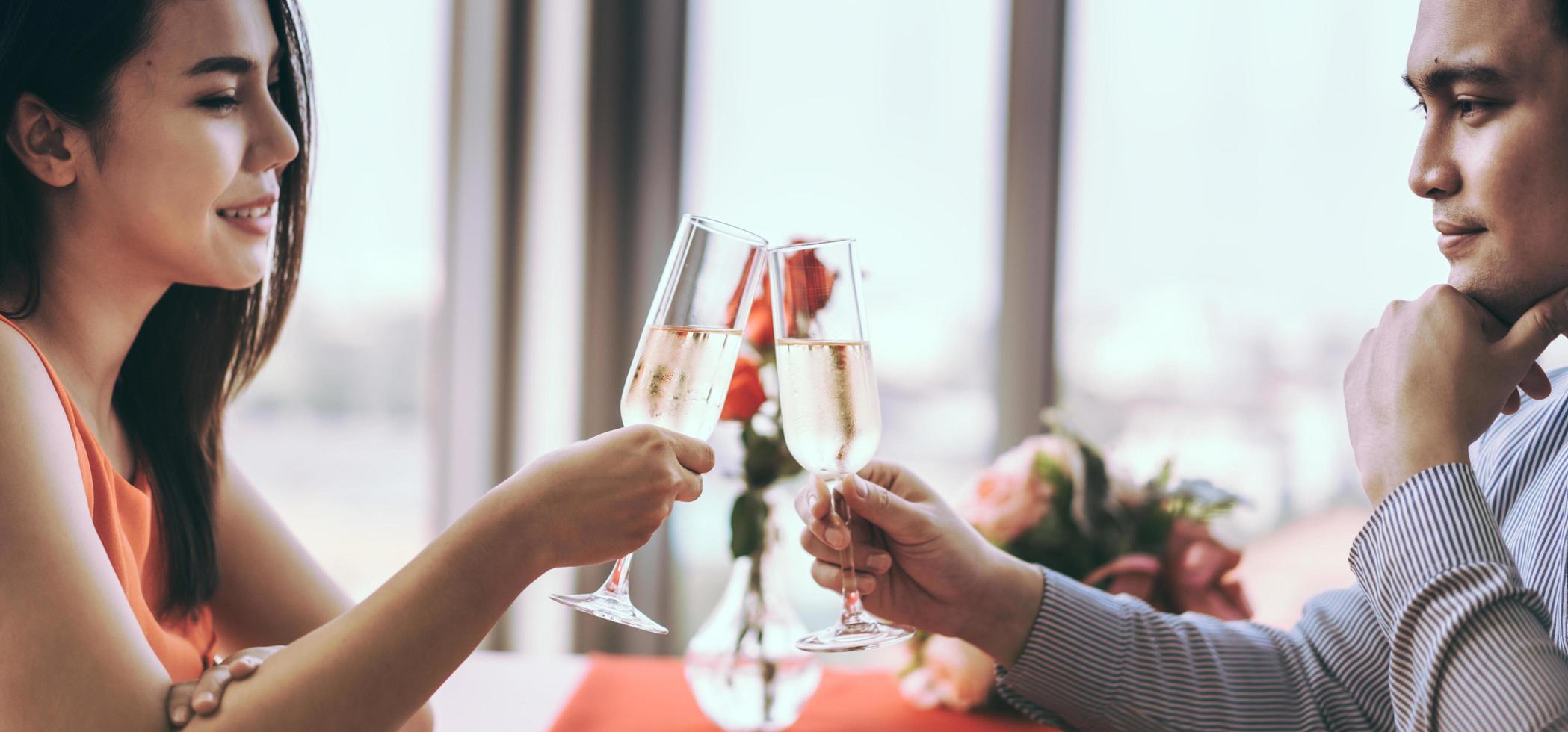 Smile asian lover couple man and woman hand hold a champagne drink and cheer. photo