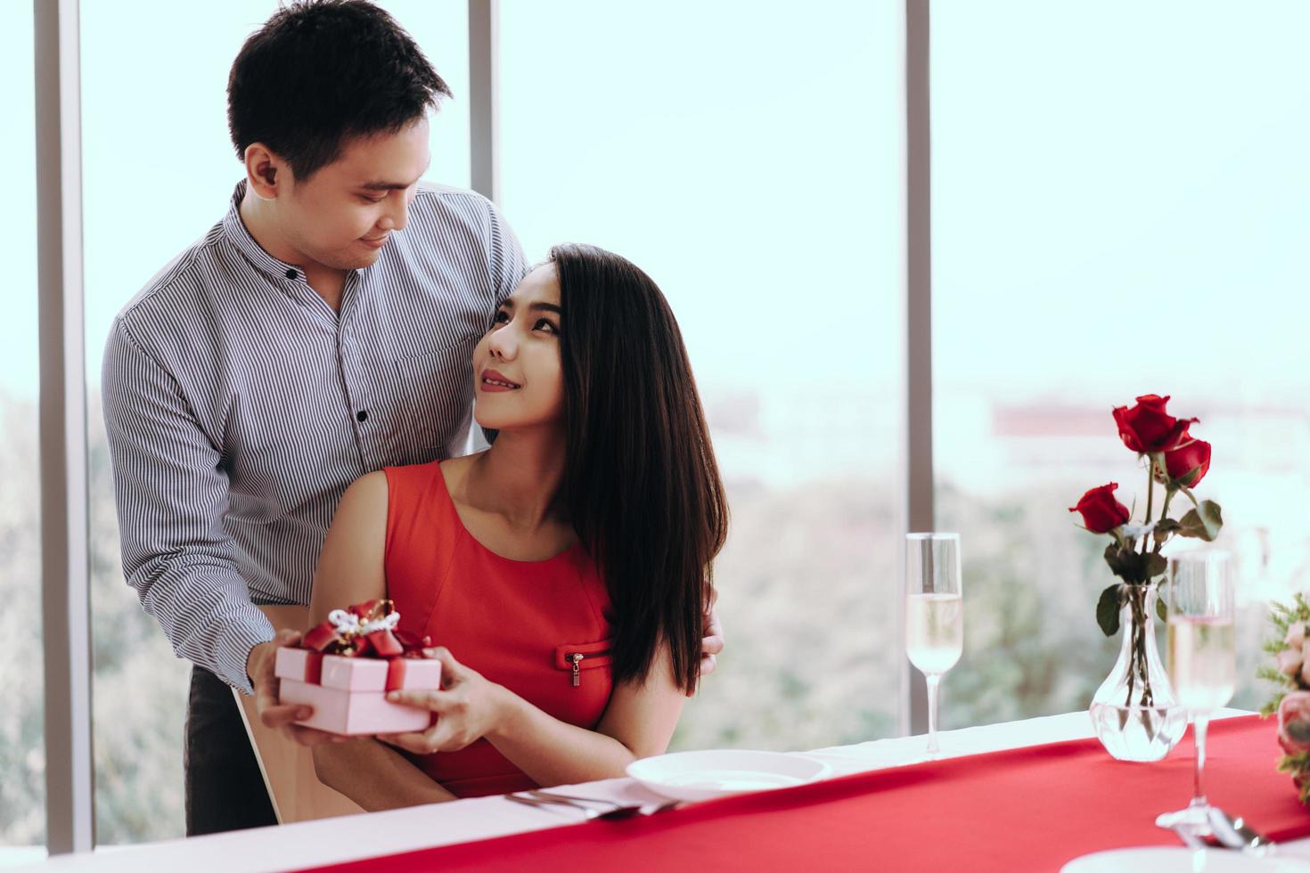 Man couple hand hold a romantic present red gift box give it to girlfriend. photo