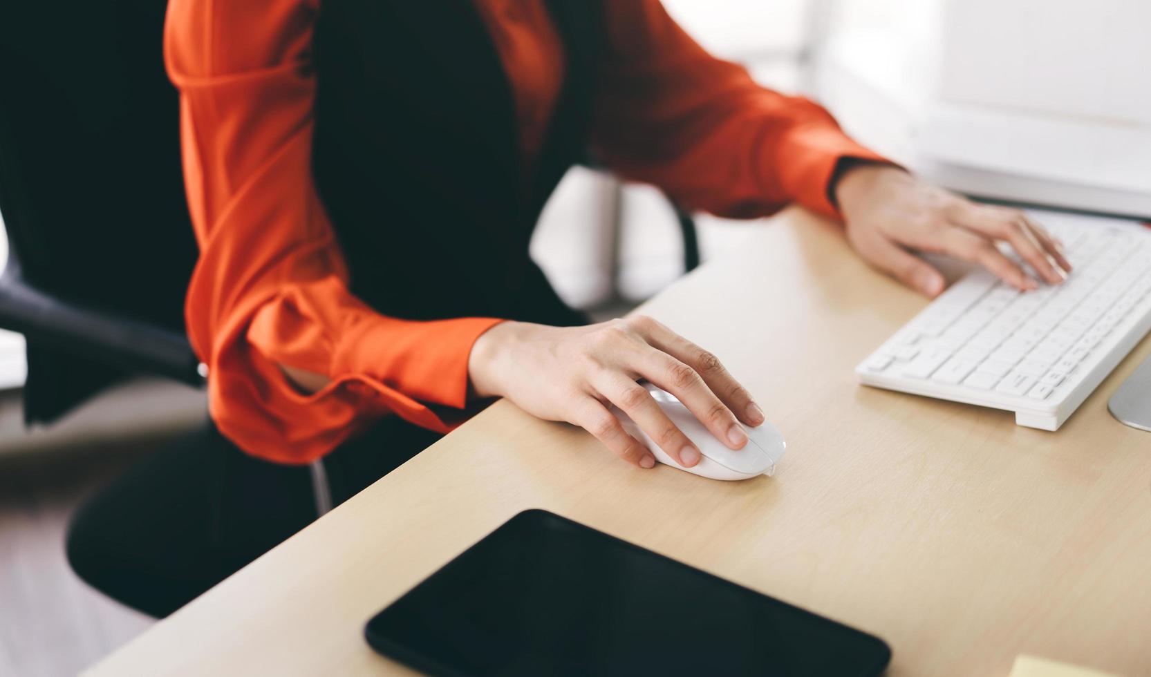 Business woman hand holding mouse using internet computer work in office. photo