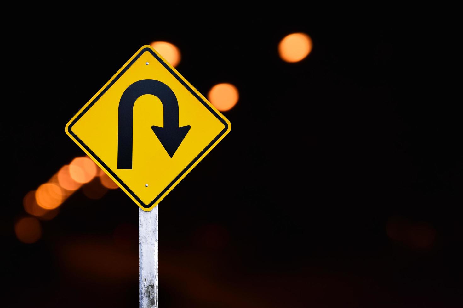 Right turn sign on white pole with clouds and blue sky background. photo