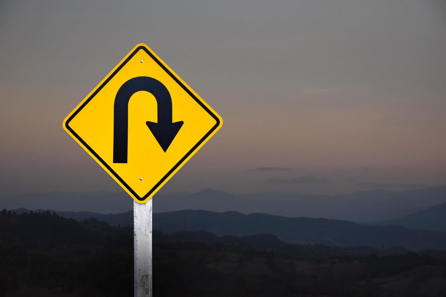 Right turn sign on white pole with clouds and blue sky background. photo