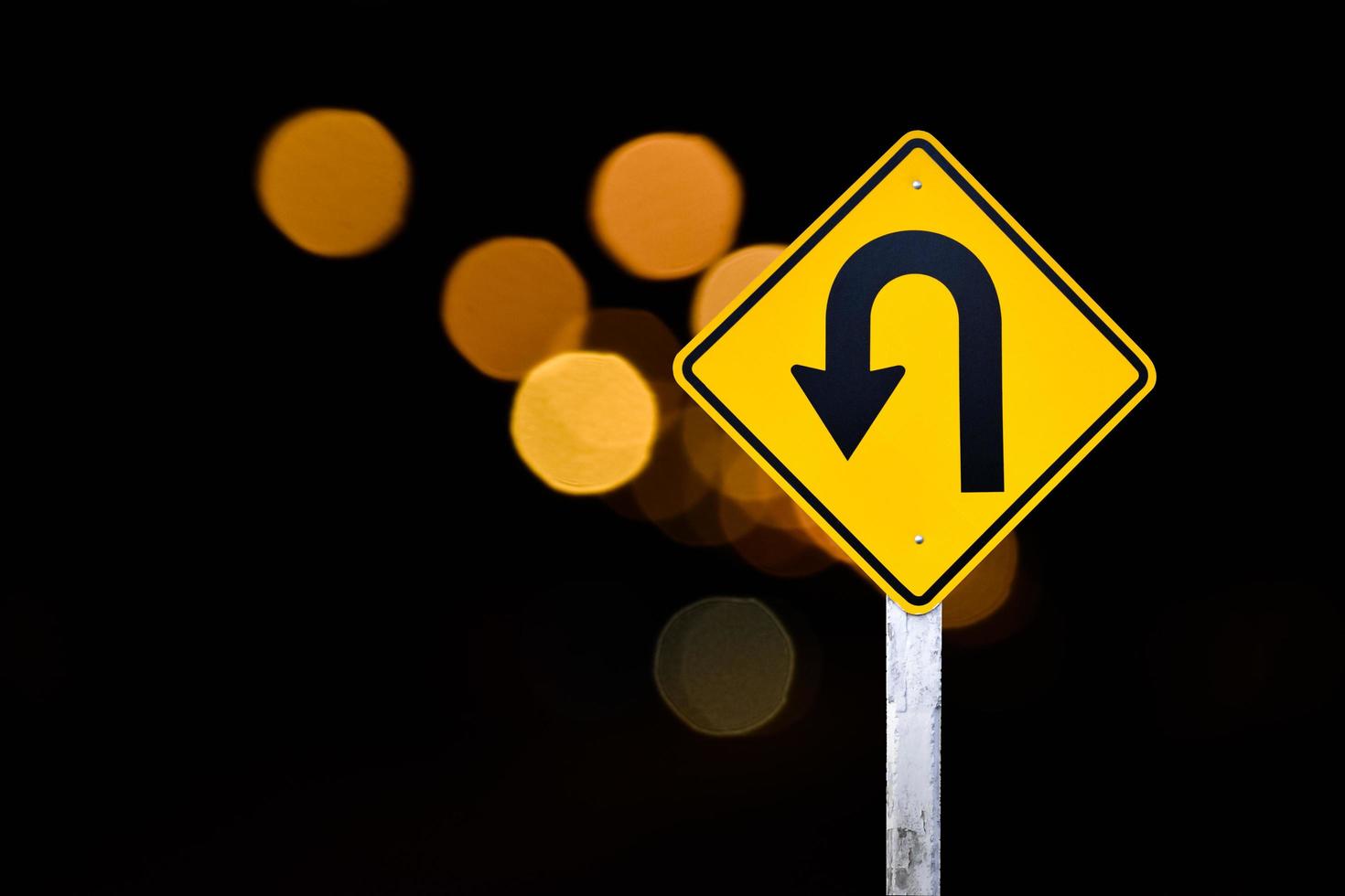 Left turn sign on white pole with clouds and blue sky background. photo