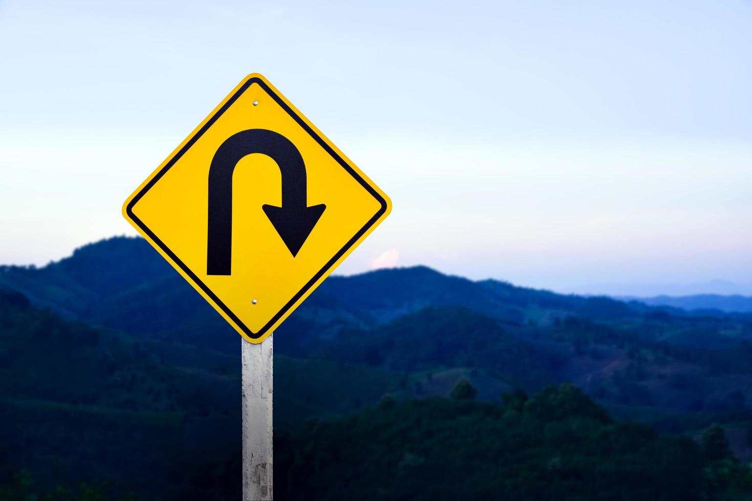 Right turn sign on white pole with clouds and blue sky background. photo