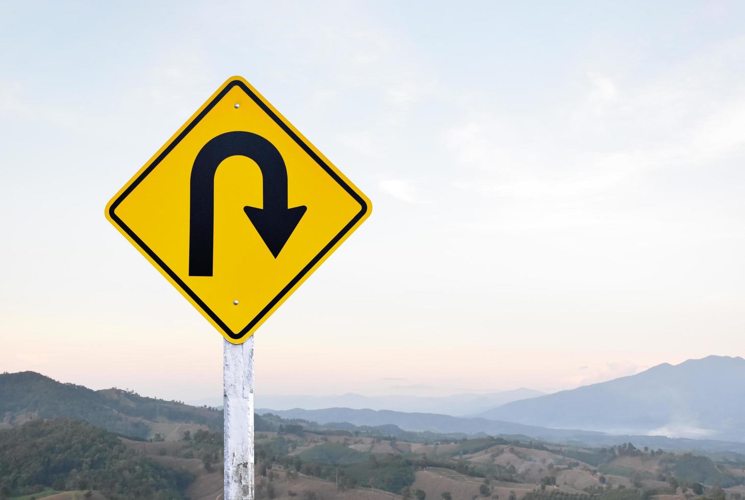 Right turn sign on white pole with clouds and blue sky background. photo