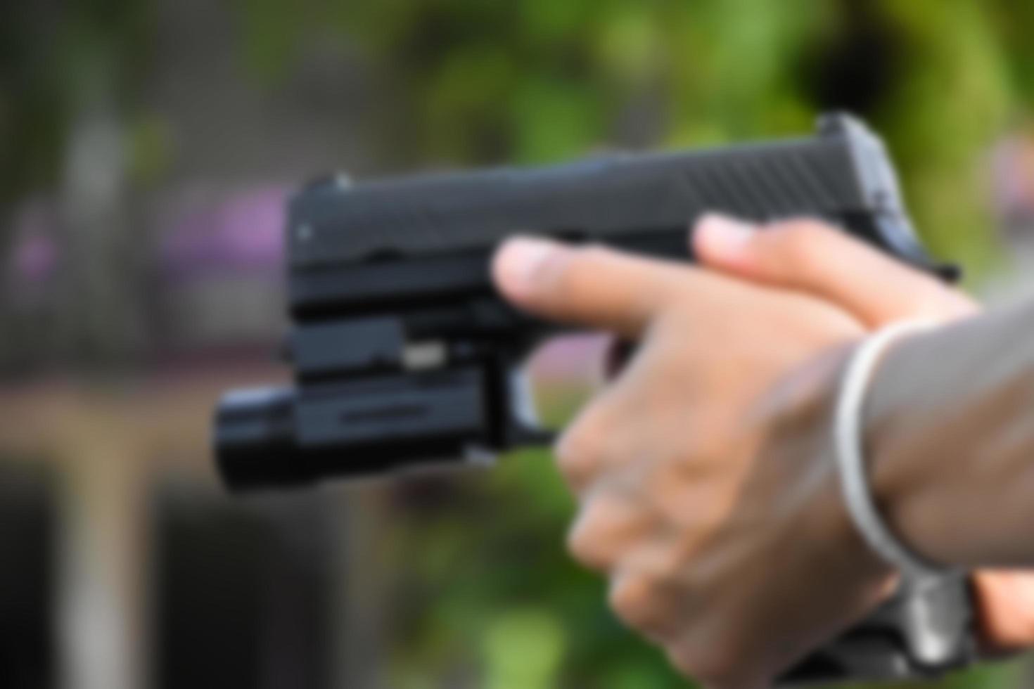 9mm automatic pistol which added troch under the muzzle holding in hand, copy space, soft and selective focus on pistol. photo