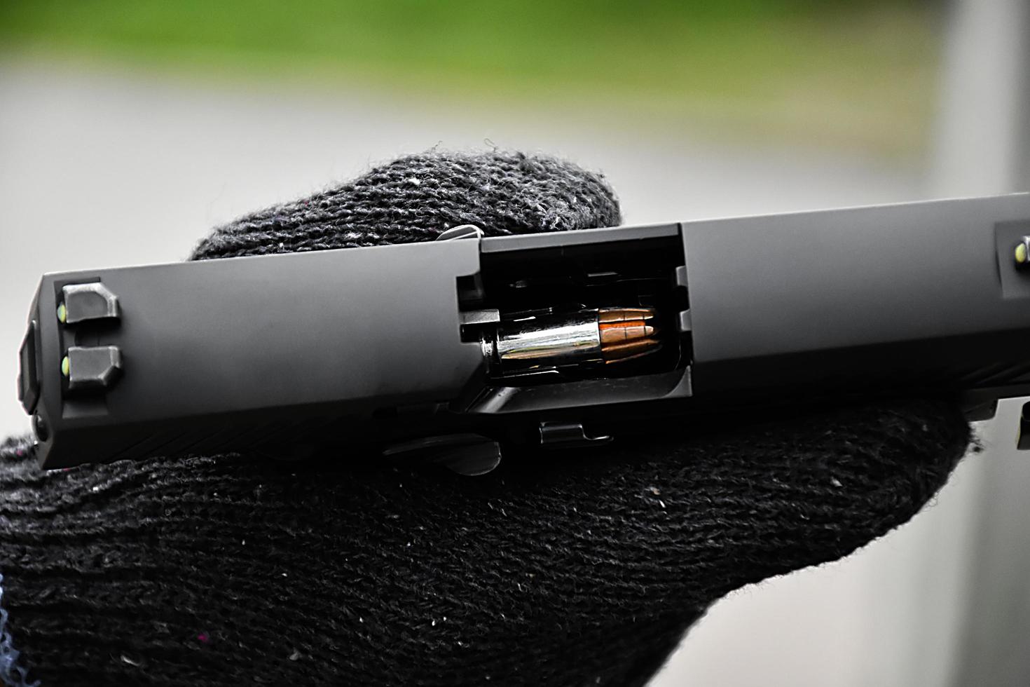 Closeup view of 9mm automatic pistol chamber which is holding in hand, selective and soft focus. photo