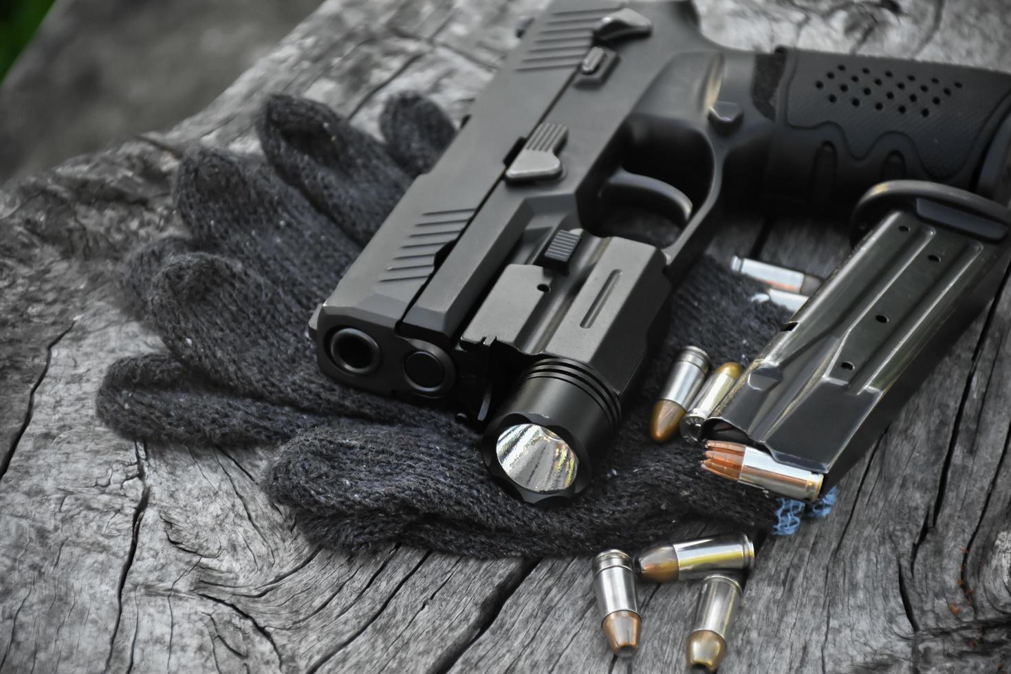 9mm automatic pistol which added troch under the muzzle holding in hand, copy space, soft and selective focus on pistol. photo