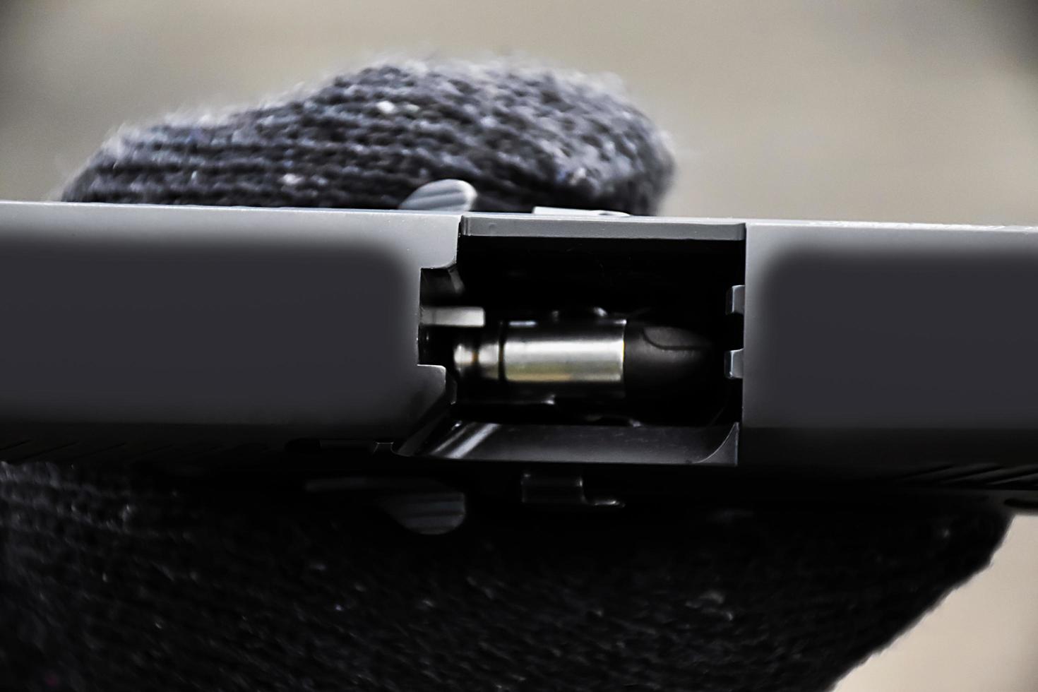 Closeup view of 9mm automatic pistol chamber which is holding in hand, selective and soft focus. photo