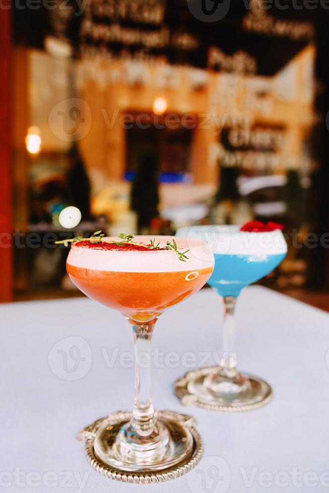 Blue curacao and beidge cocktails standing on the table outdoor photo