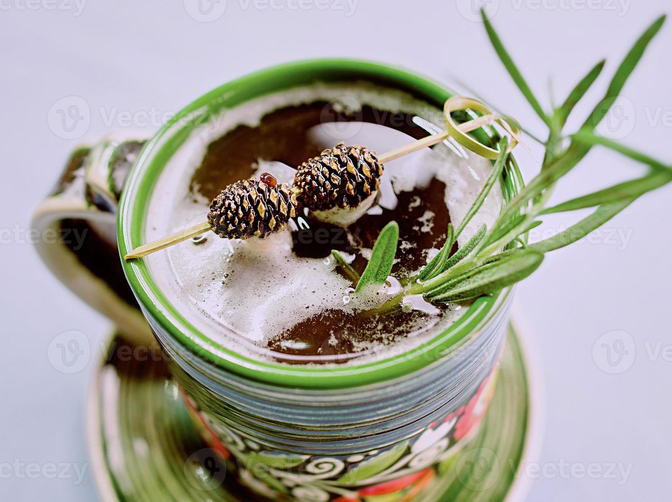 Warm strong alcohol cocktail with syrup with rosemary and bump on a top in the cup photo