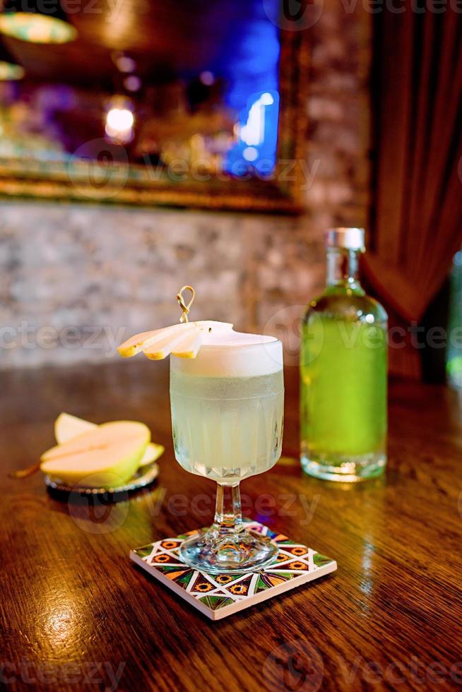 italian pear cocktail with pear and liquor on the table photo