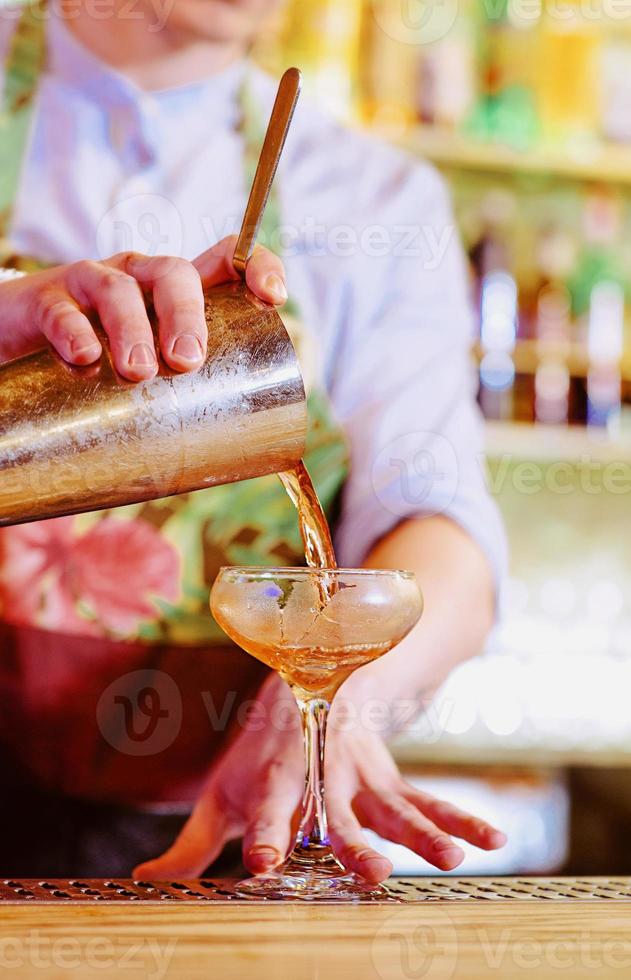 manos de barman haciendo cóctel de alcohol foto