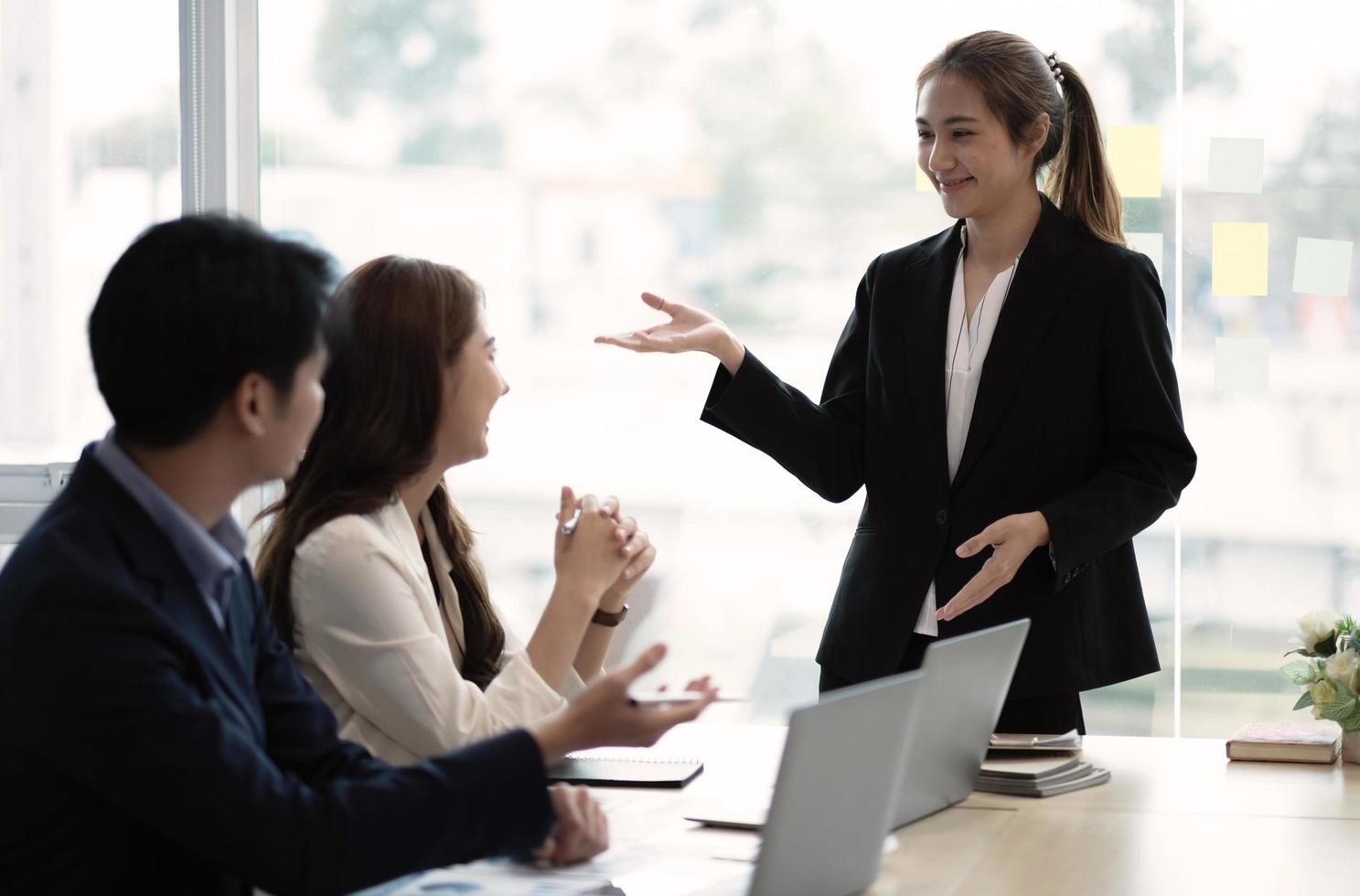 Beautiful business people are using gadgets, talking and smiling during the conference in office photo