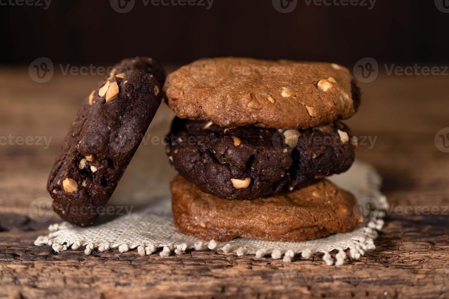 pila de galletas de maní y chocolate en la mesa de madera. foto