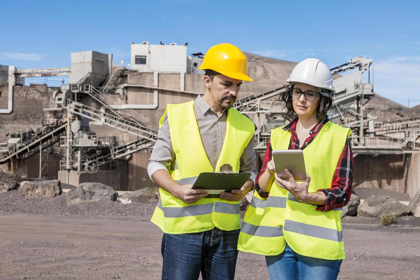 compañeros de trabajo de construcción usando tableta en área industrial foto