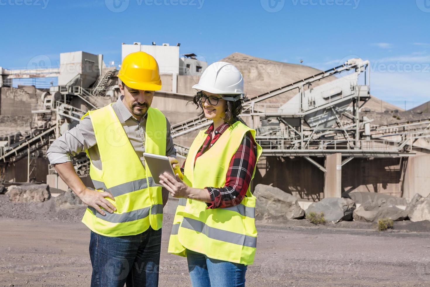 Construction engineers with tablet discussing draft photo
