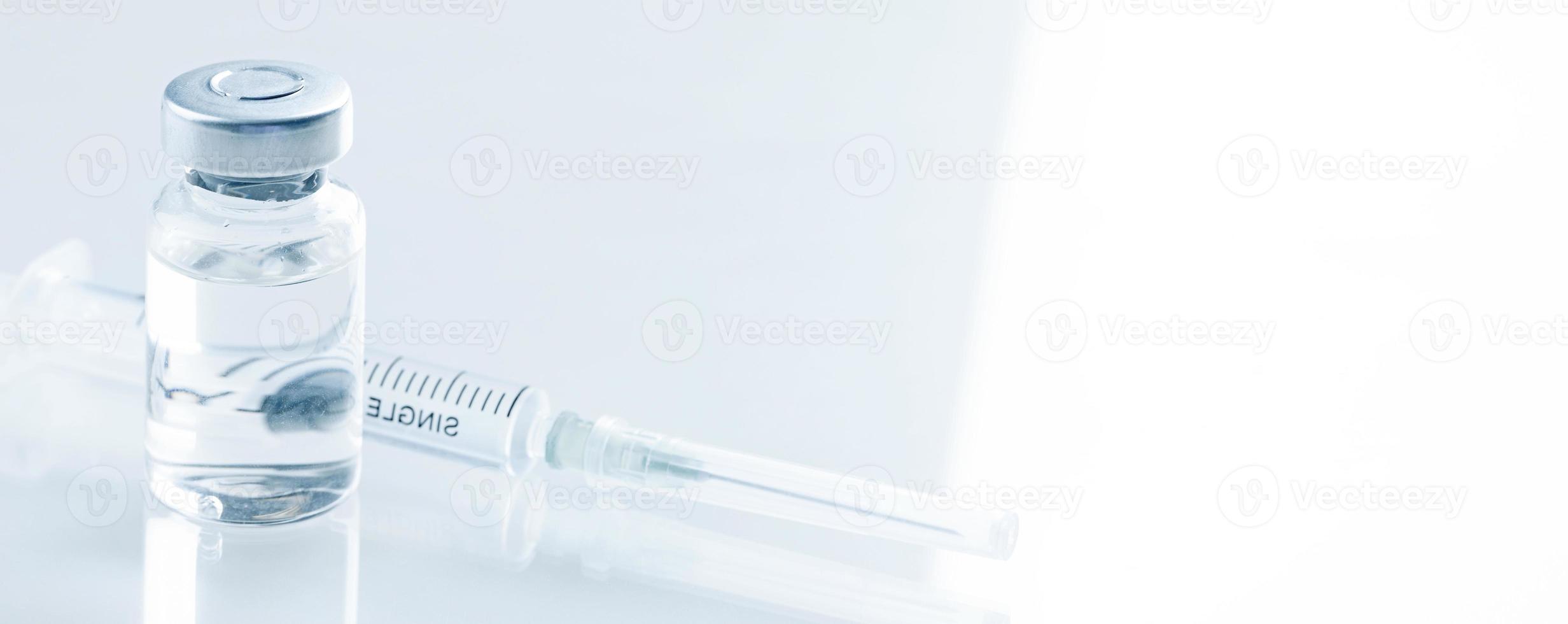 Medical syringe with a needle and a bollte with vaccine. photo