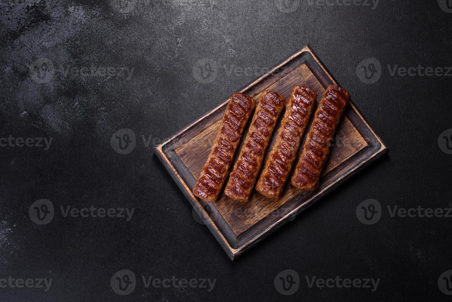 Grilled kebab with spices and herbs on a dark concrete background photo