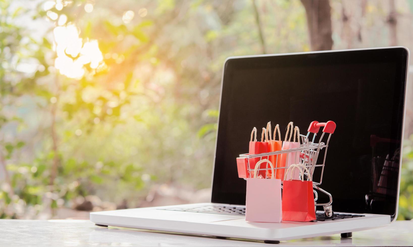 Shopping online. Shopping bags with a shopping cart logo in a trolley on laptop keyboard. Shopping service on The online web. offers home delivery photo