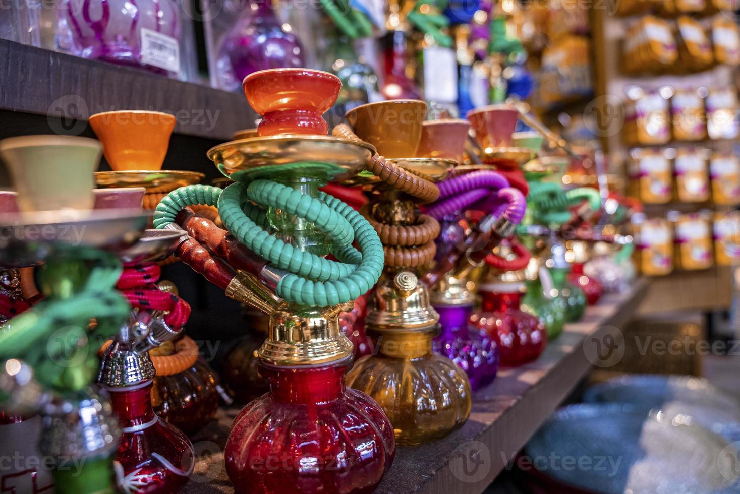 varios narguiles coloridos se exhiben en el puesto de recuerdos en el mercado a la venta foto