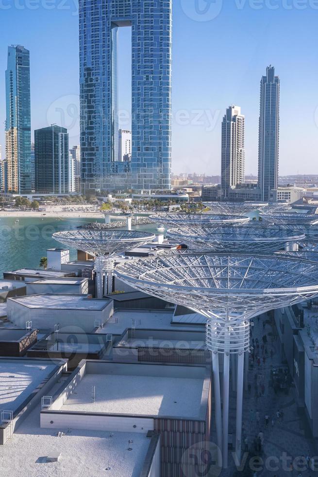 Beautiful modern skyscrapers with beach against clear blue sky photo