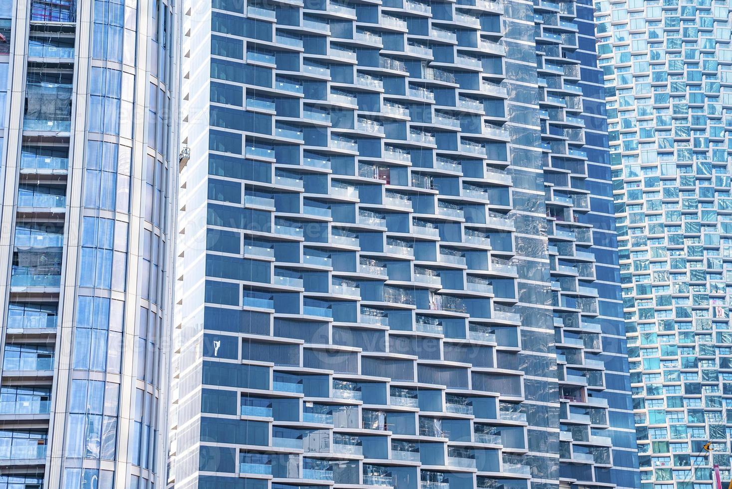 Full frame view of glass windows and balconies of residential tower photo