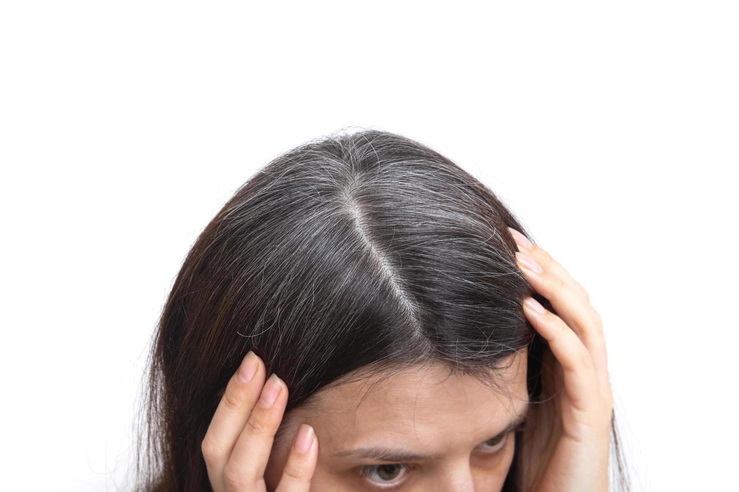 cabeza de una mujer con cabello canoso sobre un fondo blanco. el concepto de canas tempranas foto