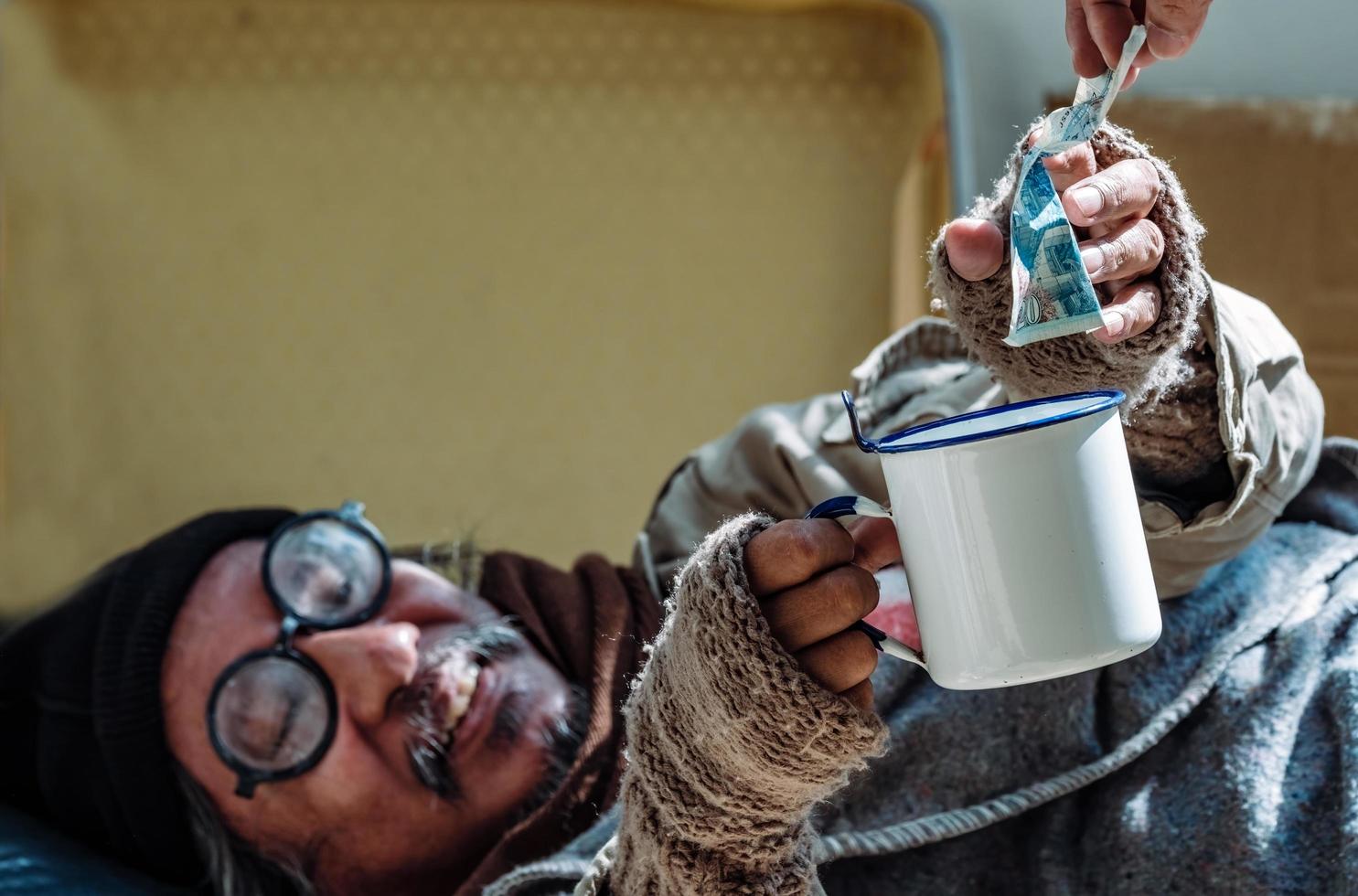 Homeless man is glad to receive a money donation as he is jobless and homelessness due to the Covid 19 epidemic. photo