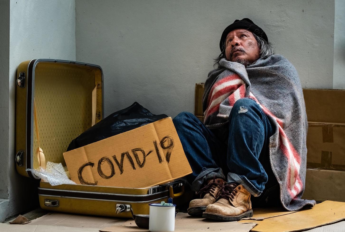 Homeless man asks the passer-bys for help as he is homeless and jobless due to the Covid 19 epidemic. photo
