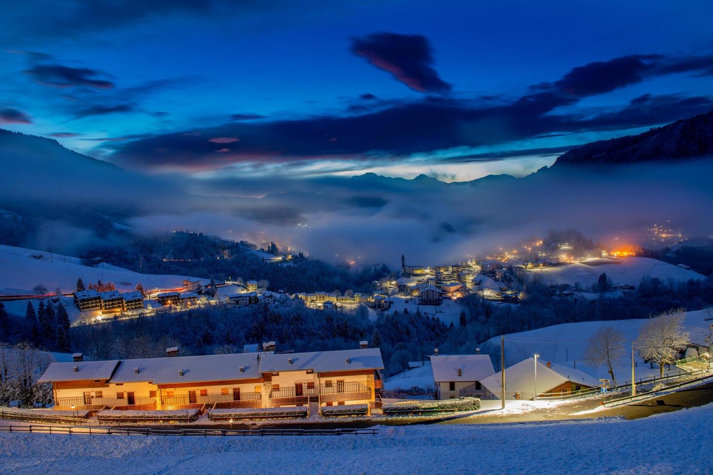 Snowy mountain village at sunset photo