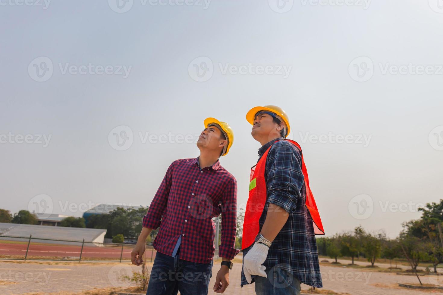 ingeniero y trabajador capataz revisando el trabajo en el sitio de construcción. los arquitectos de la construcción revisan los planes en un sitio foto