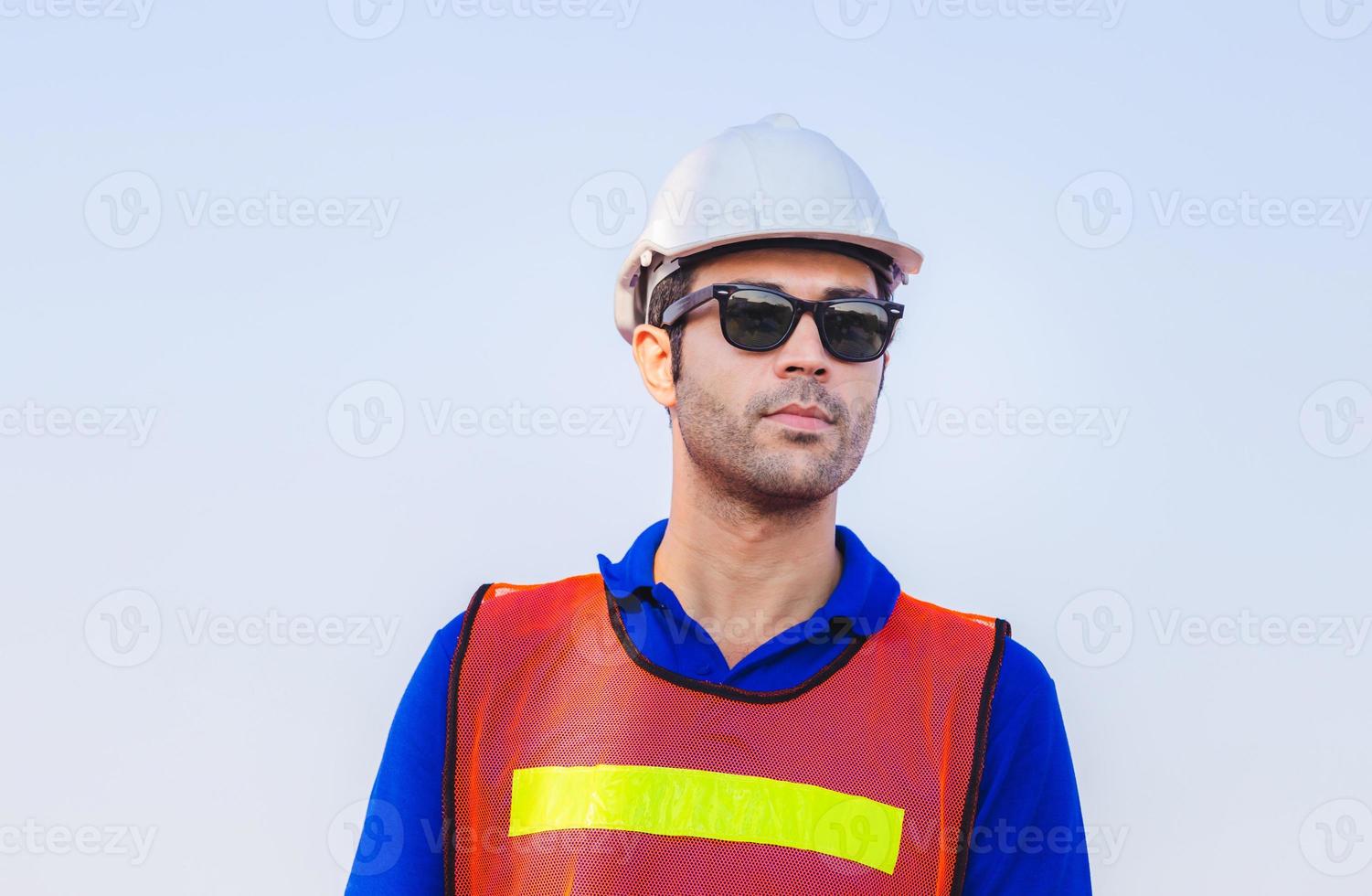 Cheerful factory worker man in hard hat smiling and looking at sky with joy, Happiness concept photo