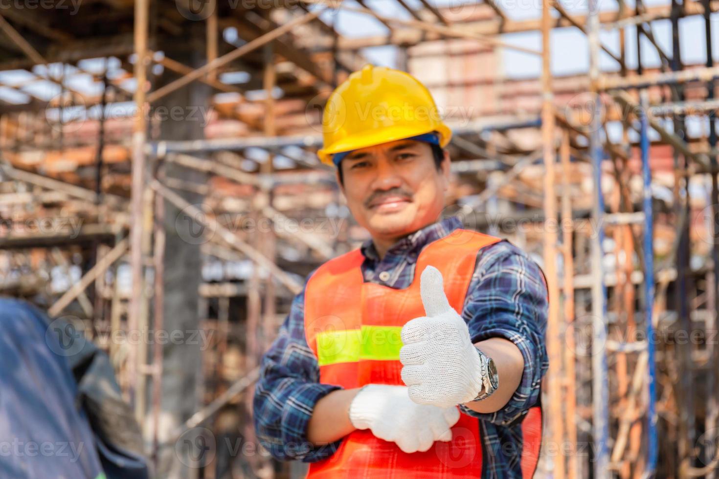 ingeniero trabajador mano dando pulgar hacia arriba sobre el sitio de construcción borroso, concepto exitoso foto