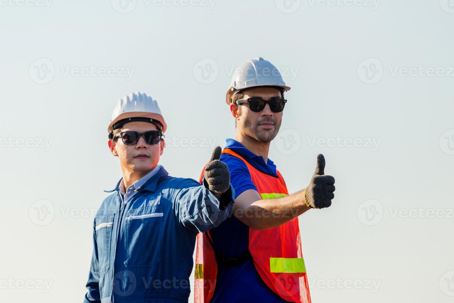 Cheerful factory worker and engineer man smiling with giving thumbs up as sign of Success photo