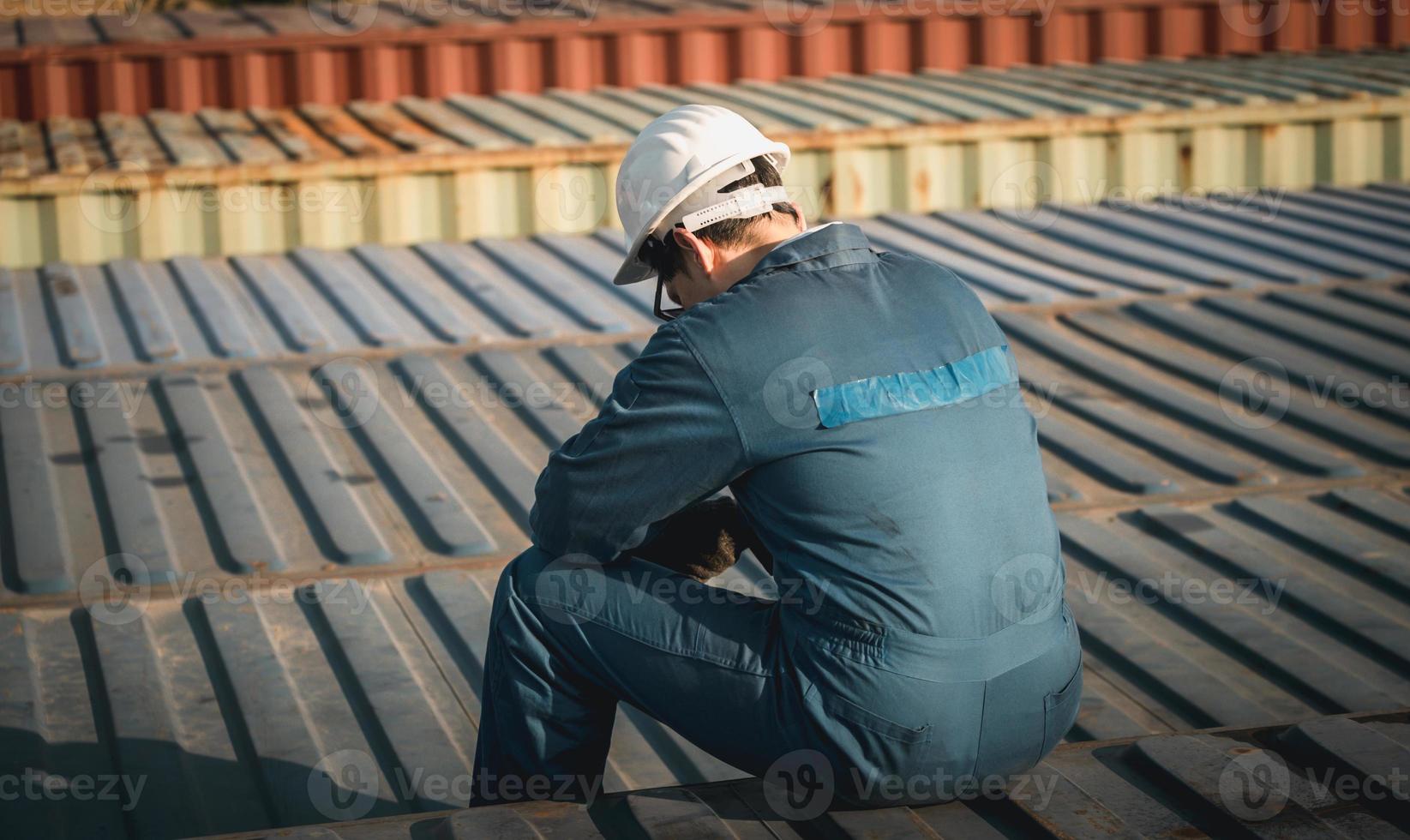 Lonely Foreman worker lost in depression on the containers box in the cargo, feeling sadness concept photo