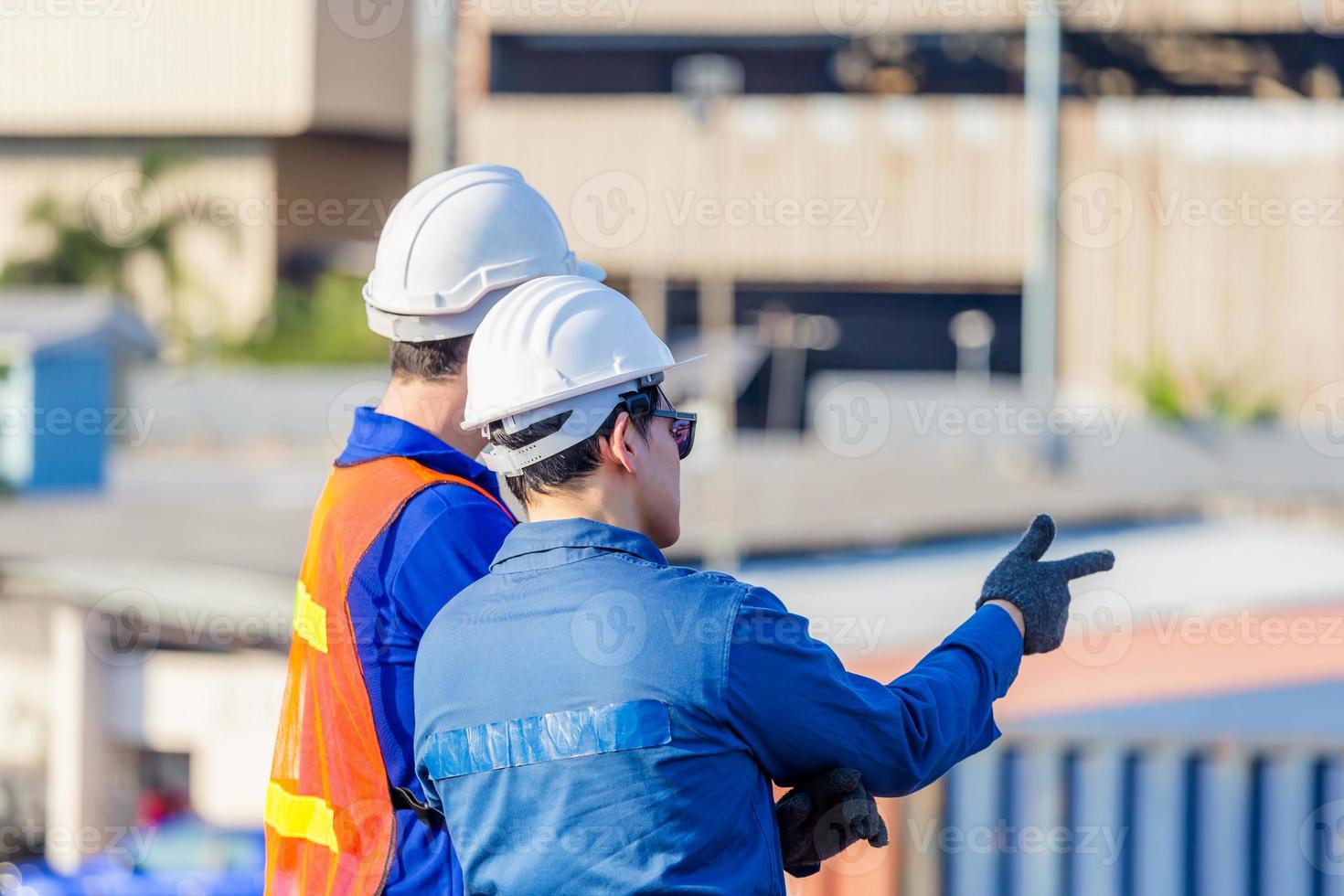 Worker man in hardhat and safety vest and foreman checking control loading containers box from cargo, Teamwork concept photo