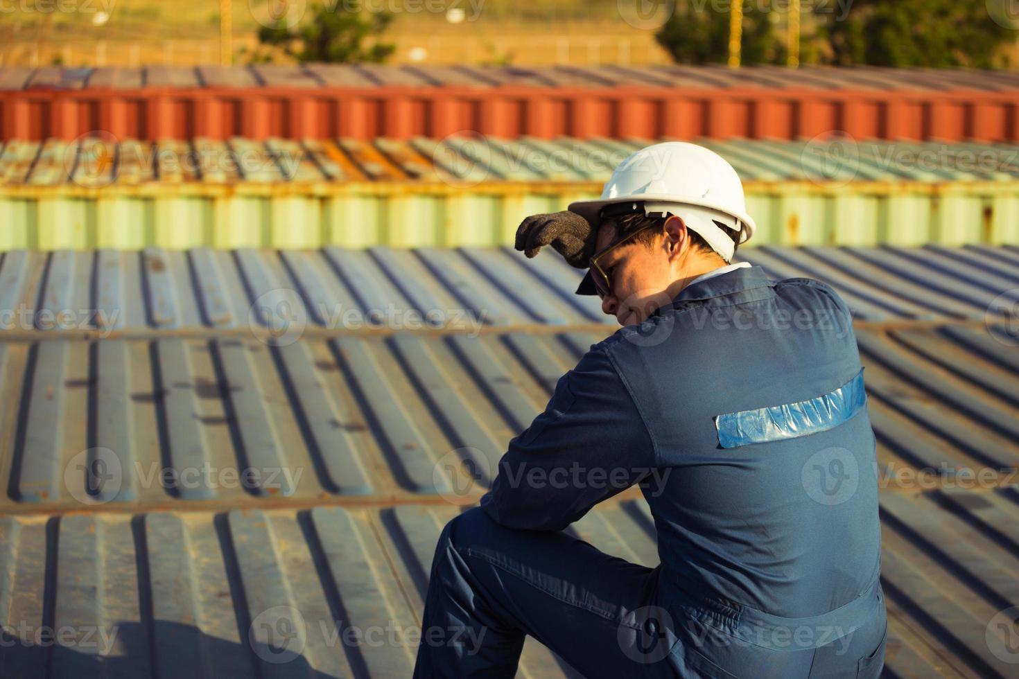 Lonely Foreman worker lost in depression on the containers box in the cargo, feeling sadness concept photo