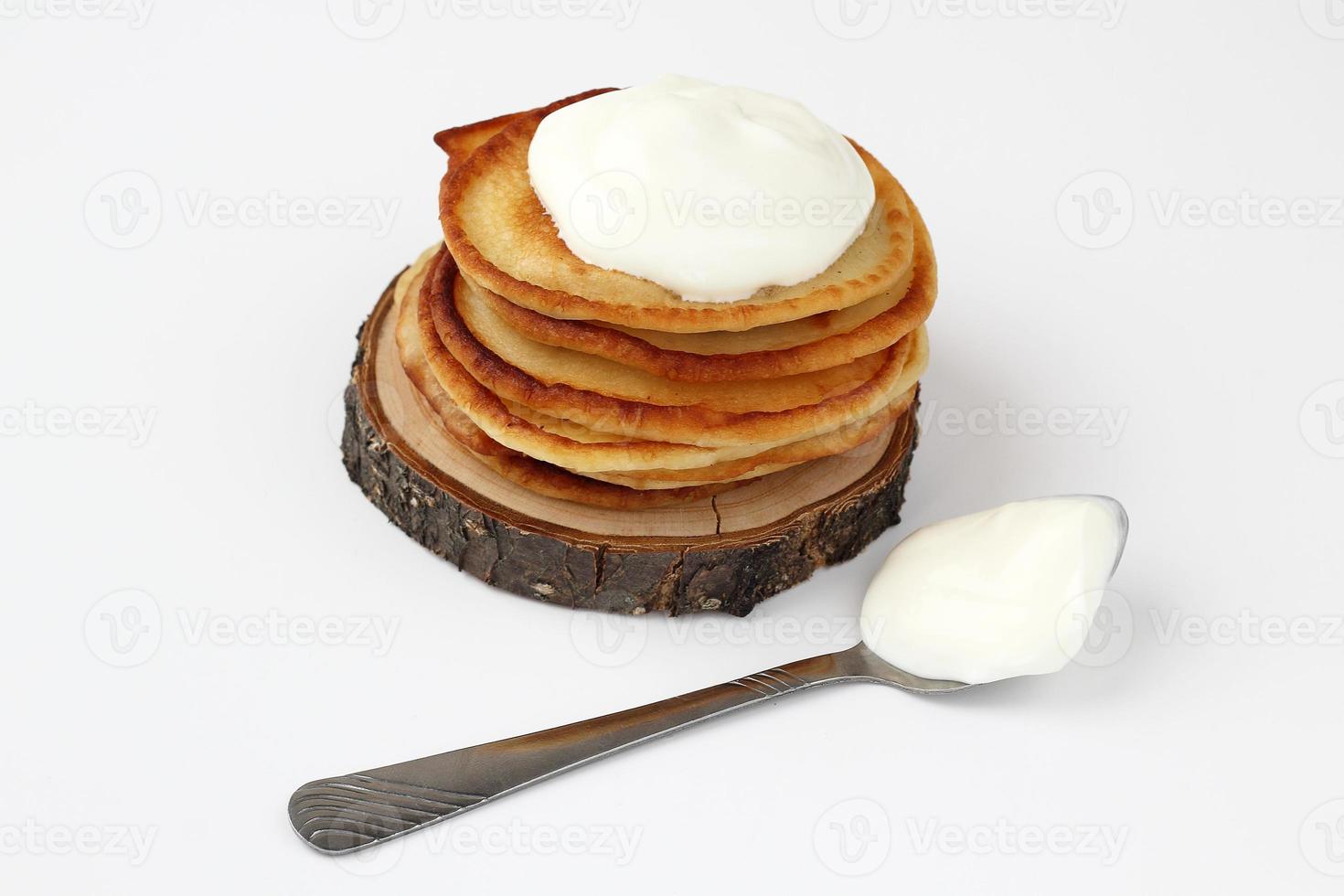 stack of pancakes with sour cream on the piece wood photo