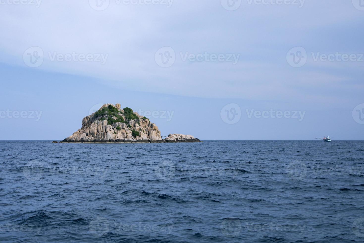 isla de roca y mar azul profundo en el golfo de tailandia foto