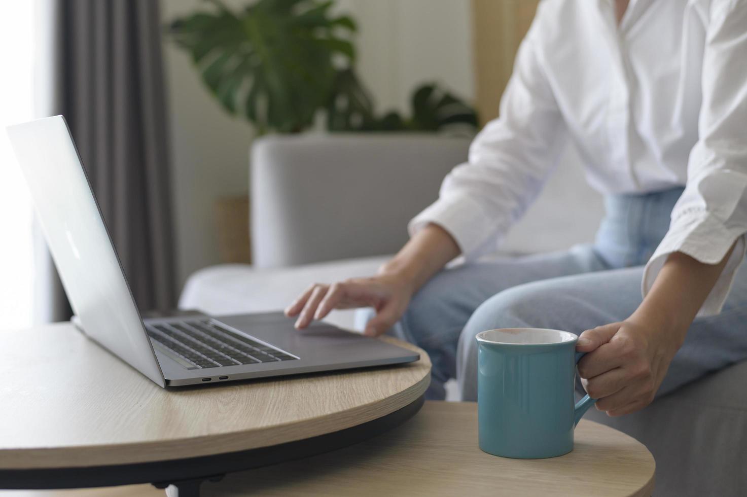 Young beautiful woman is working with her computer at home. photo