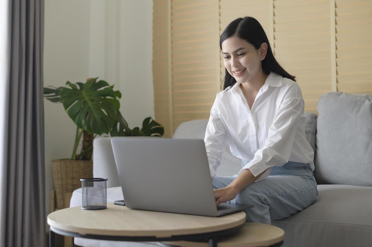 Young beautiful woman is working with her computer at home. photo