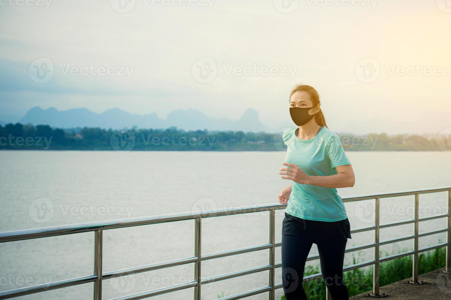 Asian woman running and exercise with wearing a protective mask COVID-19. photo