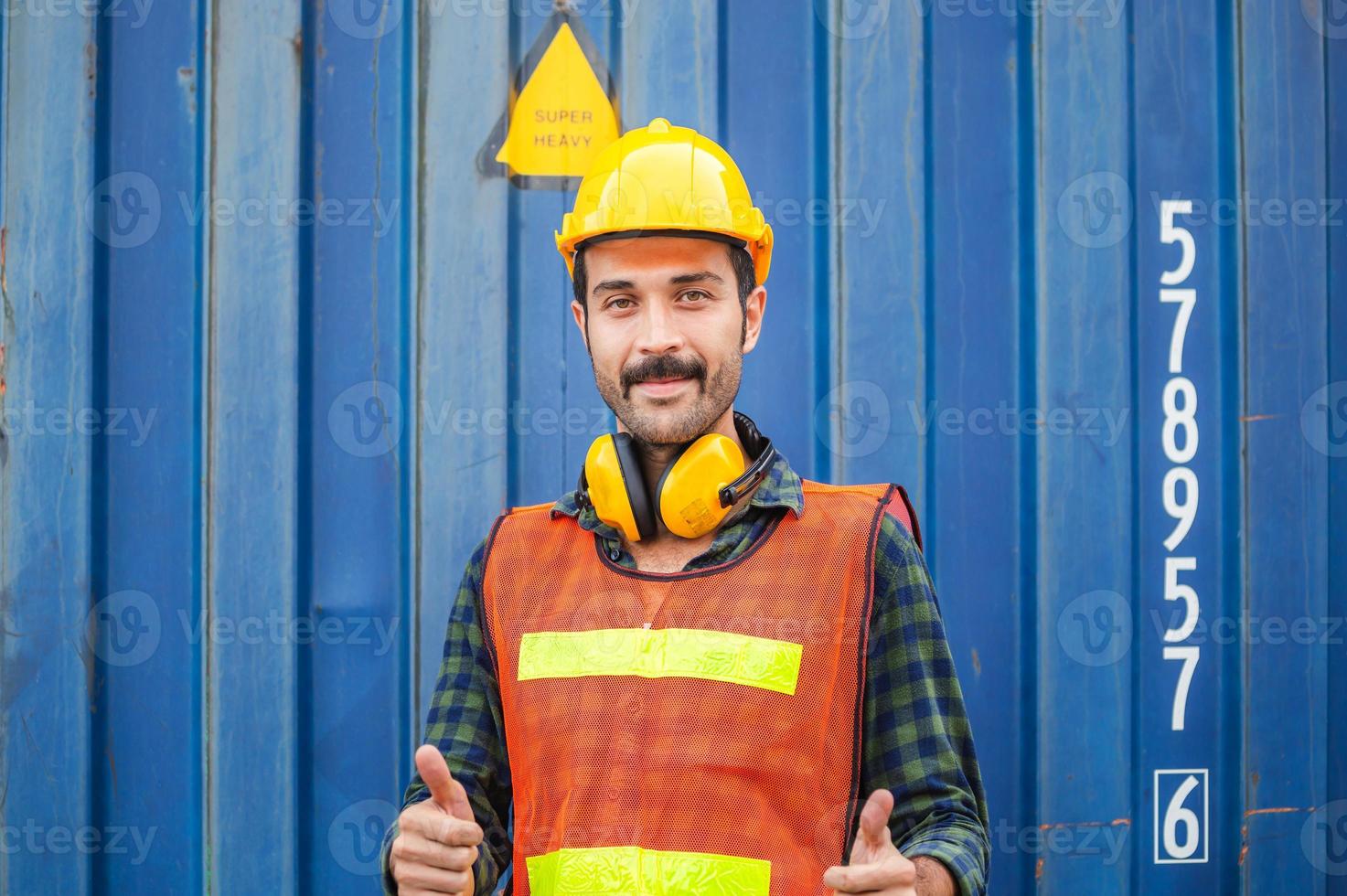 ingeniero alegre con sombrero duro sonriendo con los pulgares hacia arriba como señal de éxito foto