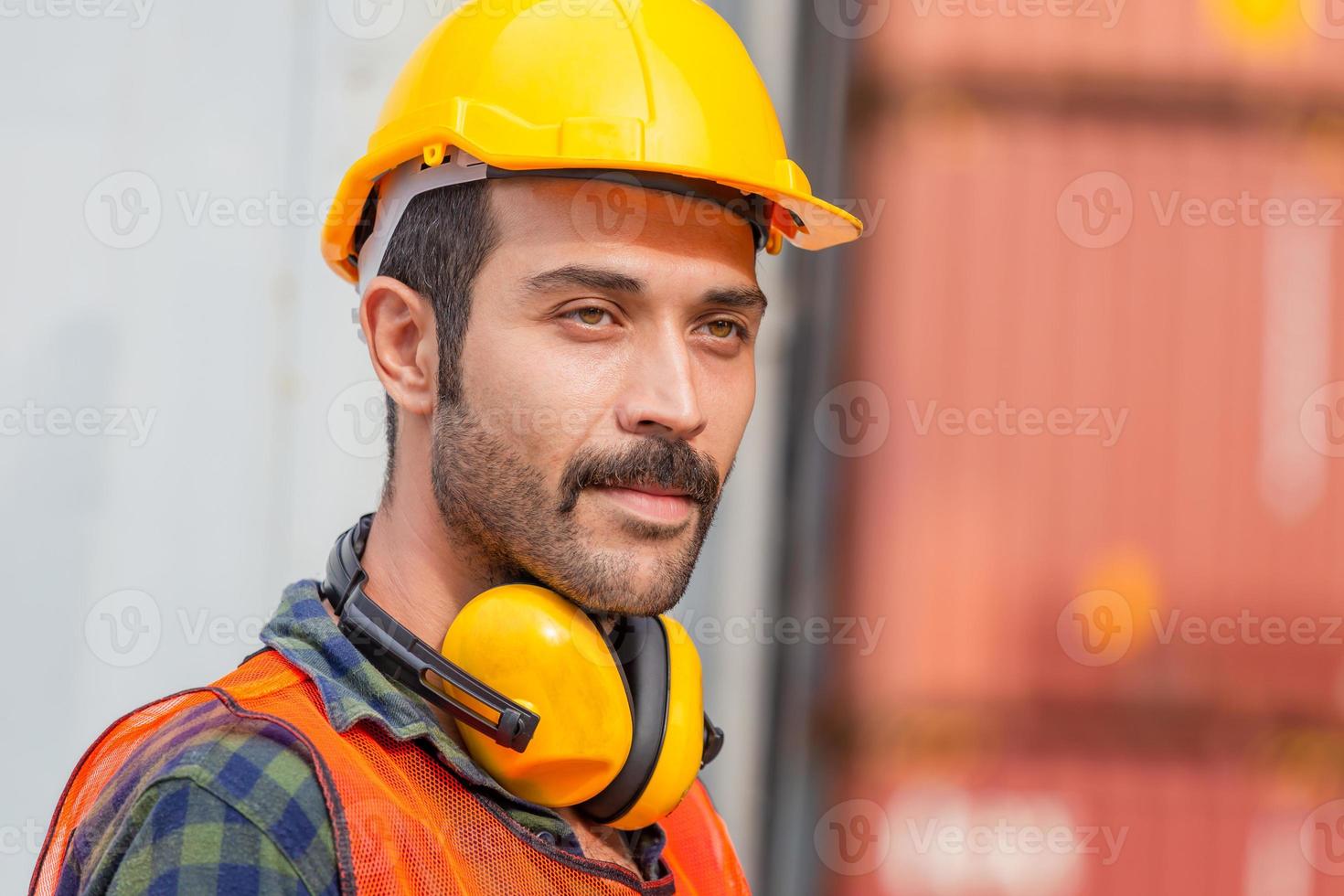 Portrait of factory worker man in hard hat and safety vest, Engineer man with containers box background at cargo photo