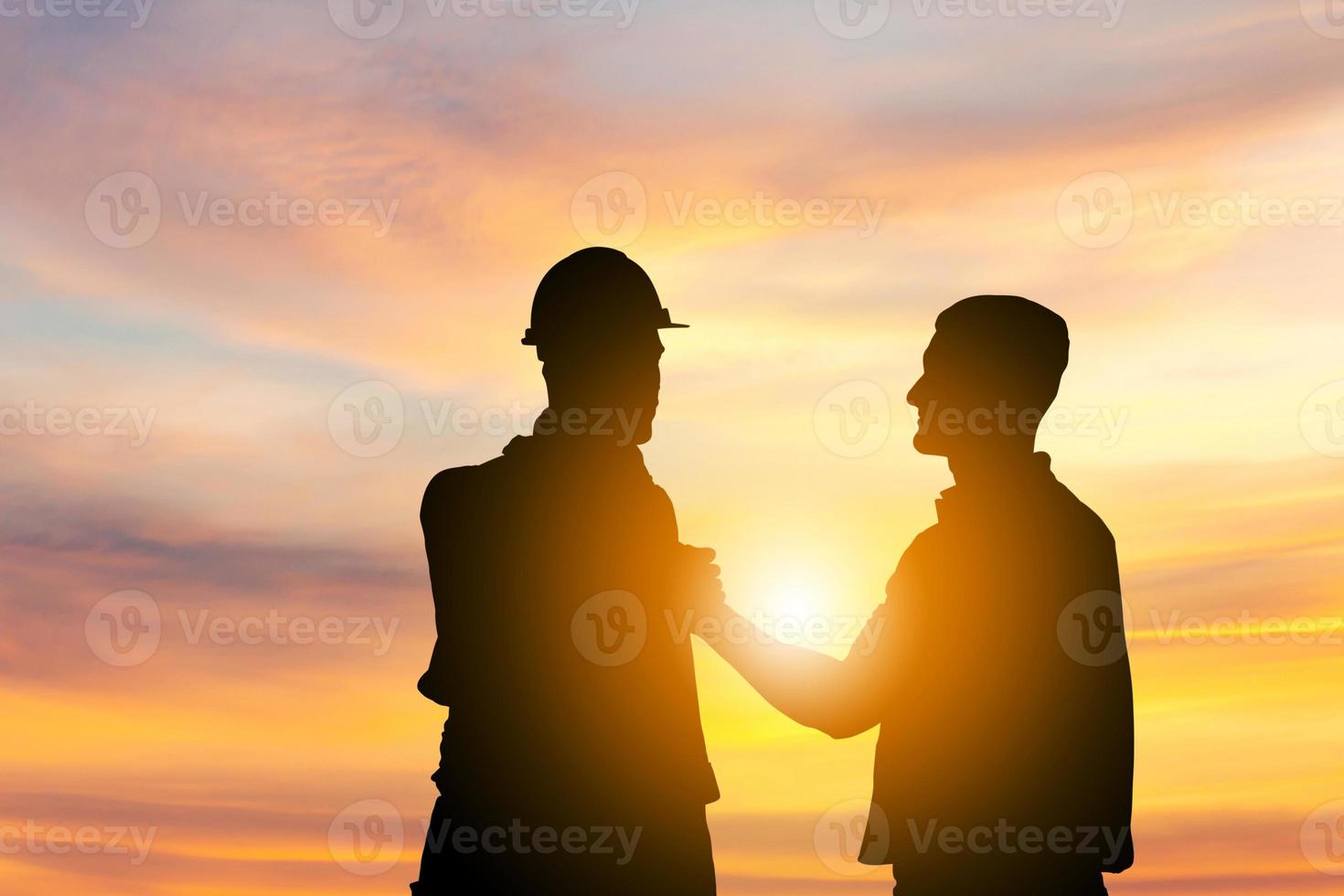 silueta de ingeniero y capataz trabajador con camino de recorte alma hermano apretón de manos, cierre de pulgar apretón de manos o homie apretón de manos fondo de puesta de sol foto