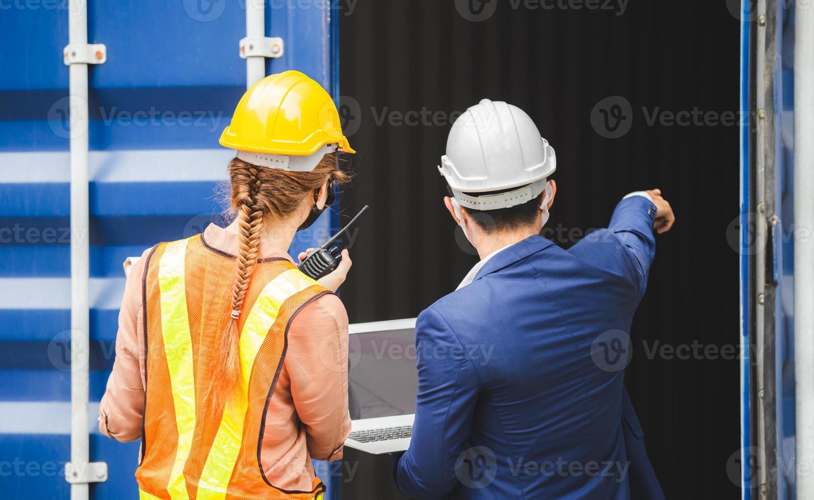 Engineer wearing protection face mask against coronavirus, Foreman worker team checking containers box from cargo photo