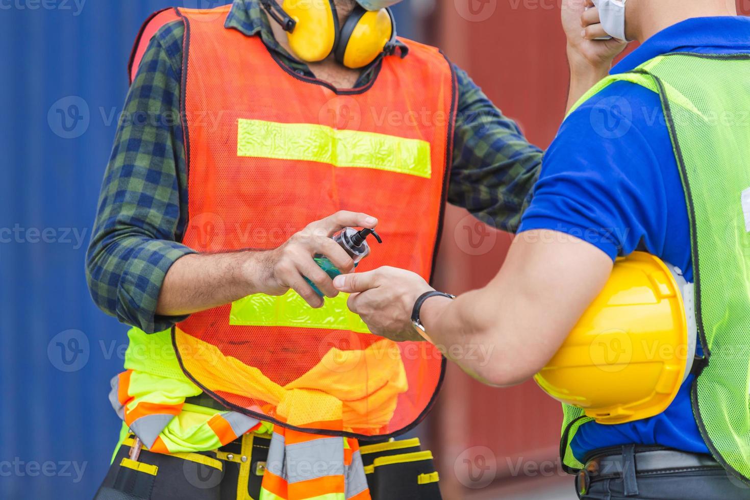 Worker man checking fever by digital thermometer for scan and protect from Coronavirus COVID 19 at cargo containers - Healthcare Concept photo