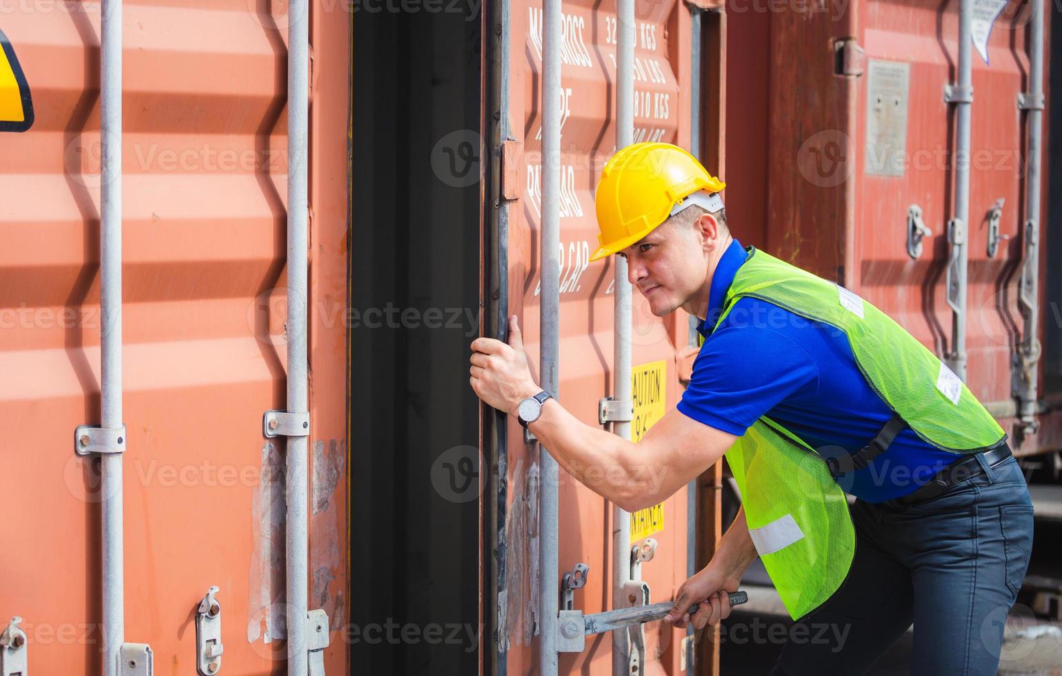 Engineer worker man in hardhat and safety vest checking containers box from cargo photo