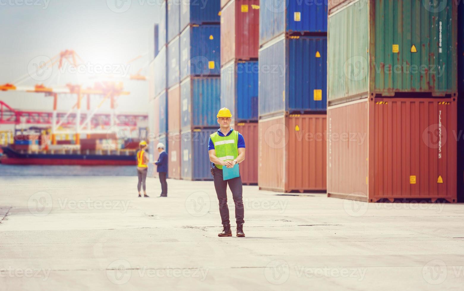 Engineer and foreman team in hardhat and safety vest control loading containers box from cargo, Logistic concept photo